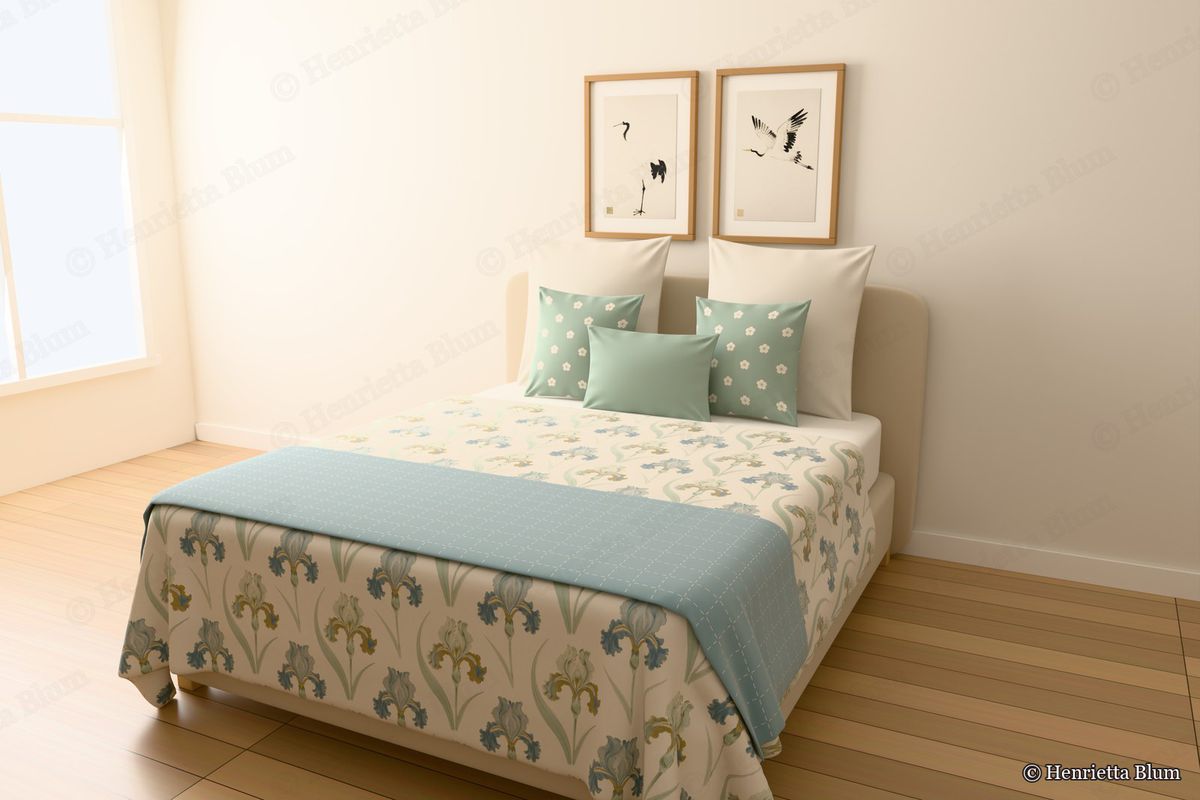 Bed with an iris-print bedspread, blossom cushions and two framed crane prints