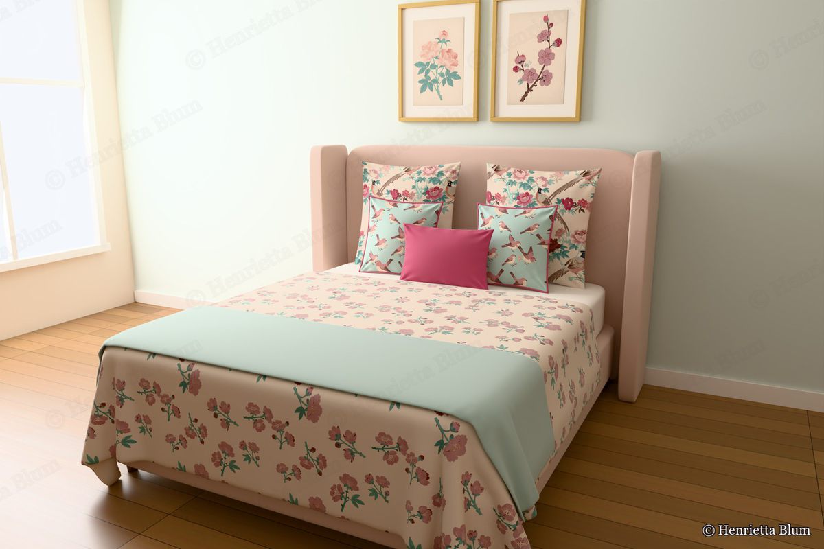 Blush bed with a blossom bedspread, bird cushions and two framed botanical prints